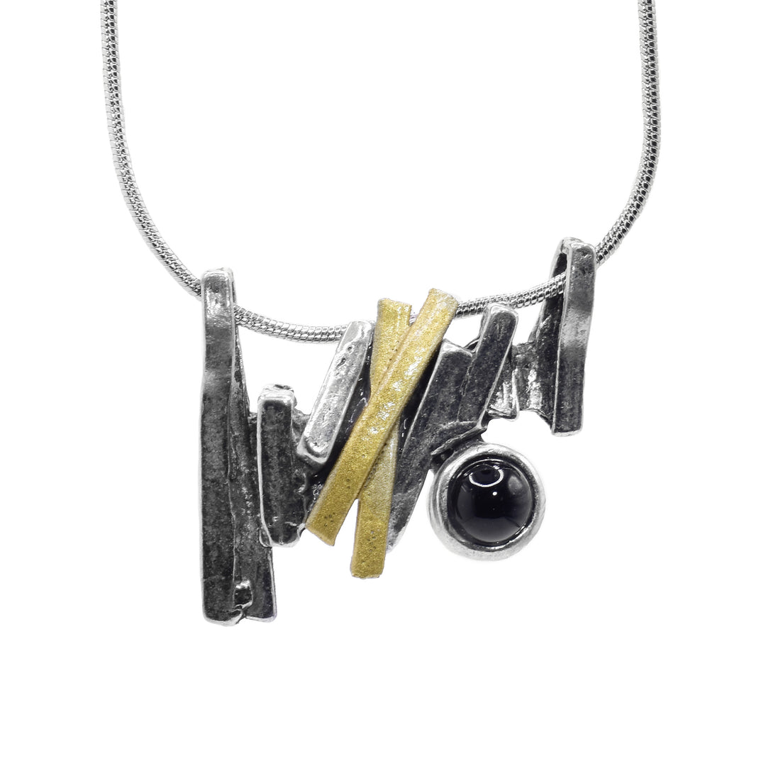 This black onyx pendant is a long, bar pendant that is made up of several gold plated and pewter strips. The strips are connected at different angles and give the piece a jagged appearance There is a black onyx gem held in the pendant..