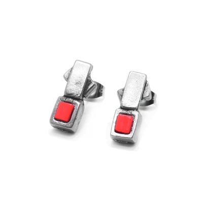 These red glass earrings studs have pewter squares that frame red glass squares. The glass pieces are attached to other pewter squares which have studs on the back.