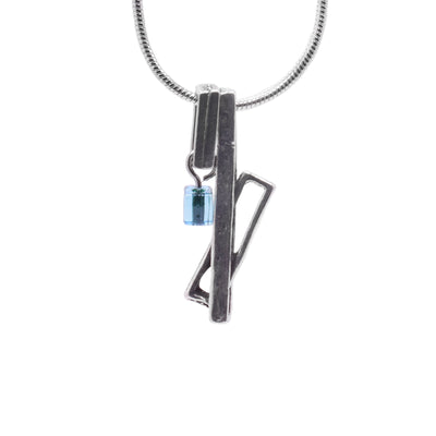 This unique pewter pendant is made up of three cutout, pewter rectangles. A long rectangle drops down with another one linked through it at an angle. Beside this piece is another rectangle that hangs horizontally and has turquoise, glass cube charm hanging from it.