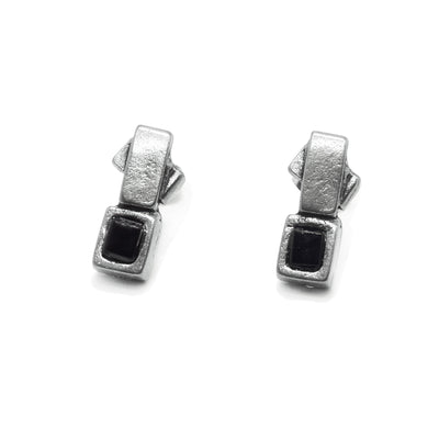 These black glass earrings studs have pewter squares that frame black glass squares. The glass pieces are attached to other pewter squares which have studs on the back.