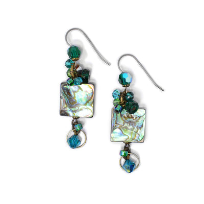 On both earrings, a square piece of abalone dangles from titanium hook. Beads with similar colours to the abalone made of Swarovski crystal and glass adorn the top and bottom. By Honica.