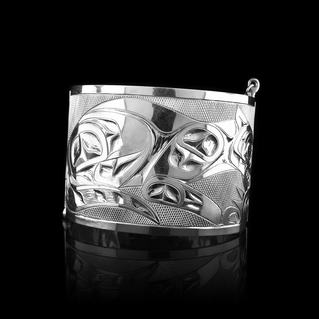 Handcrafted sterling silver hinge bracelet featuring engraved Bee and Otter designs with detailed carving.