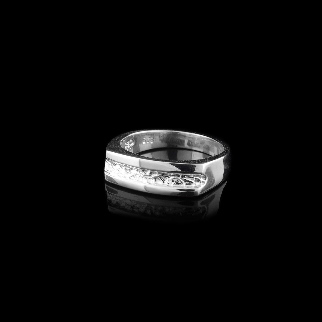 Ring is smooth all the way around and has squared top. Textured indent goes all the way across the top.