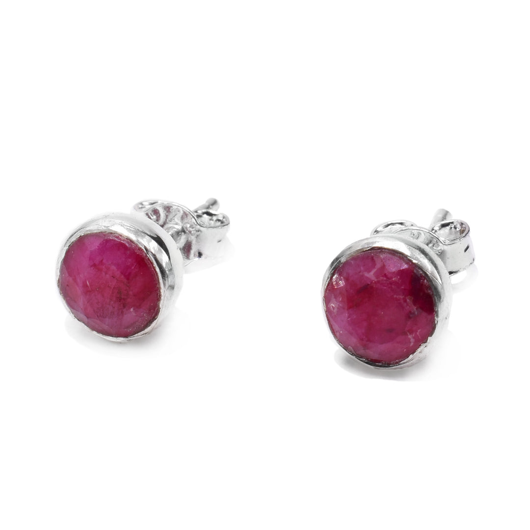 These ruby stud earrings are made from sterling silver and genuine ruby gemstones. The studs are circle shaped and have a rugged texture to them, giving the piece a rustic look.
