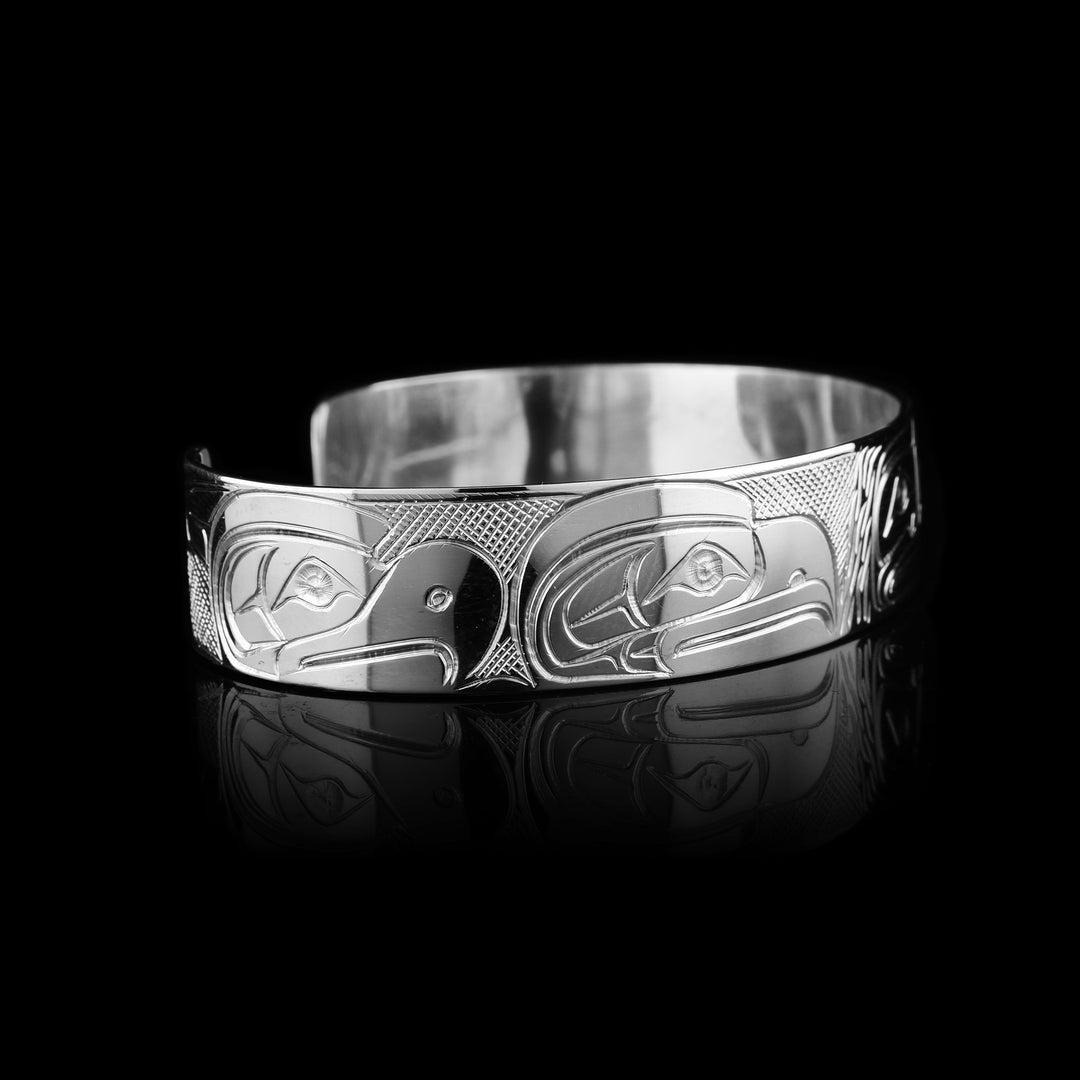 Coast Salish legend with this Travis Henry bracelet. This sterling silver cuff depicts the Sasquatch, Eagle, Raven, and Orca in a stunning display of Indigenous storytelling.