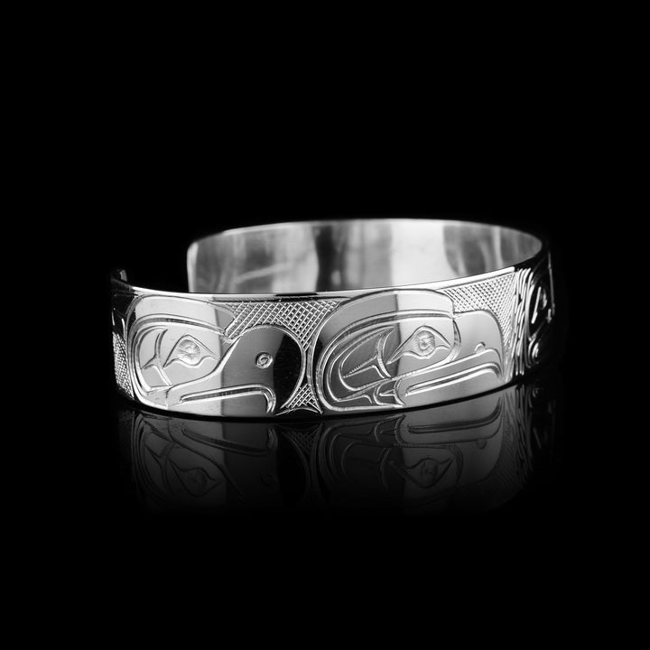 Coast Salish legend with this Travis Henry bracelet. This sterling silver cuff depicts the Sasquatch, Eagle, Raven, and Orca in a stunning display of Indigenous storytelling.