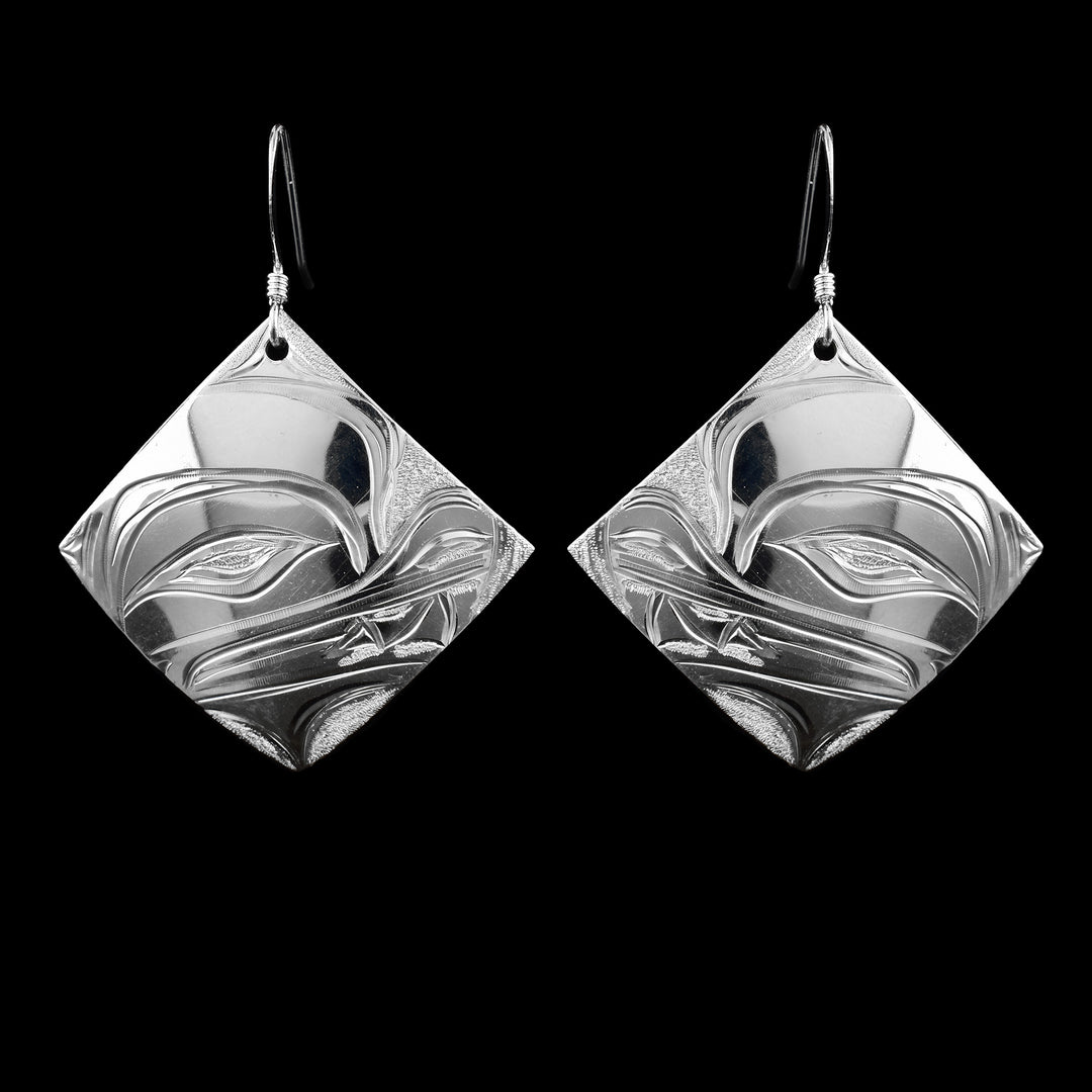 Discover these sterling silver Wolf earrings by Kwakwaka'wakw artist Cristiano Bruno. Elegant diamond-shaped drops measuring 1 3/4" x 1 1/4" with hooks.