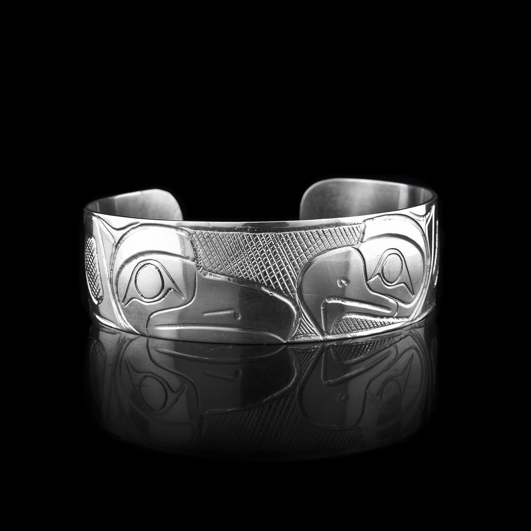 This sterling silver cuff bracelet has been carved with the legends of the eagle and the raven. There beaks meet in the middle of the bracelet.