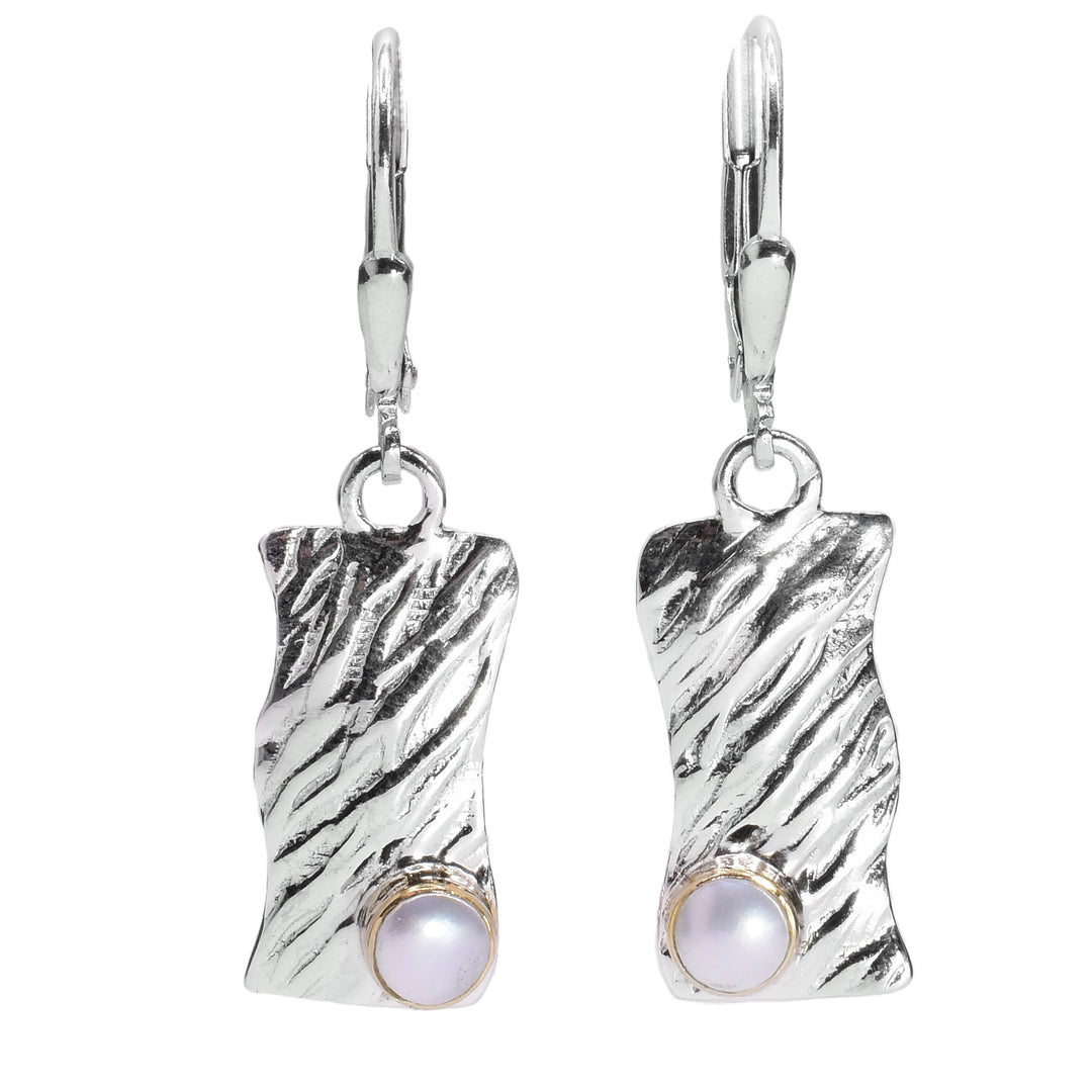These unique pearl dangle earrings are made from sterling silver, 14K gold and freshwater pearls. The hangs are wavy, rectangular and have a rippled textures on the surface of them. There is a large pearl placed in the corner and is held in gold.