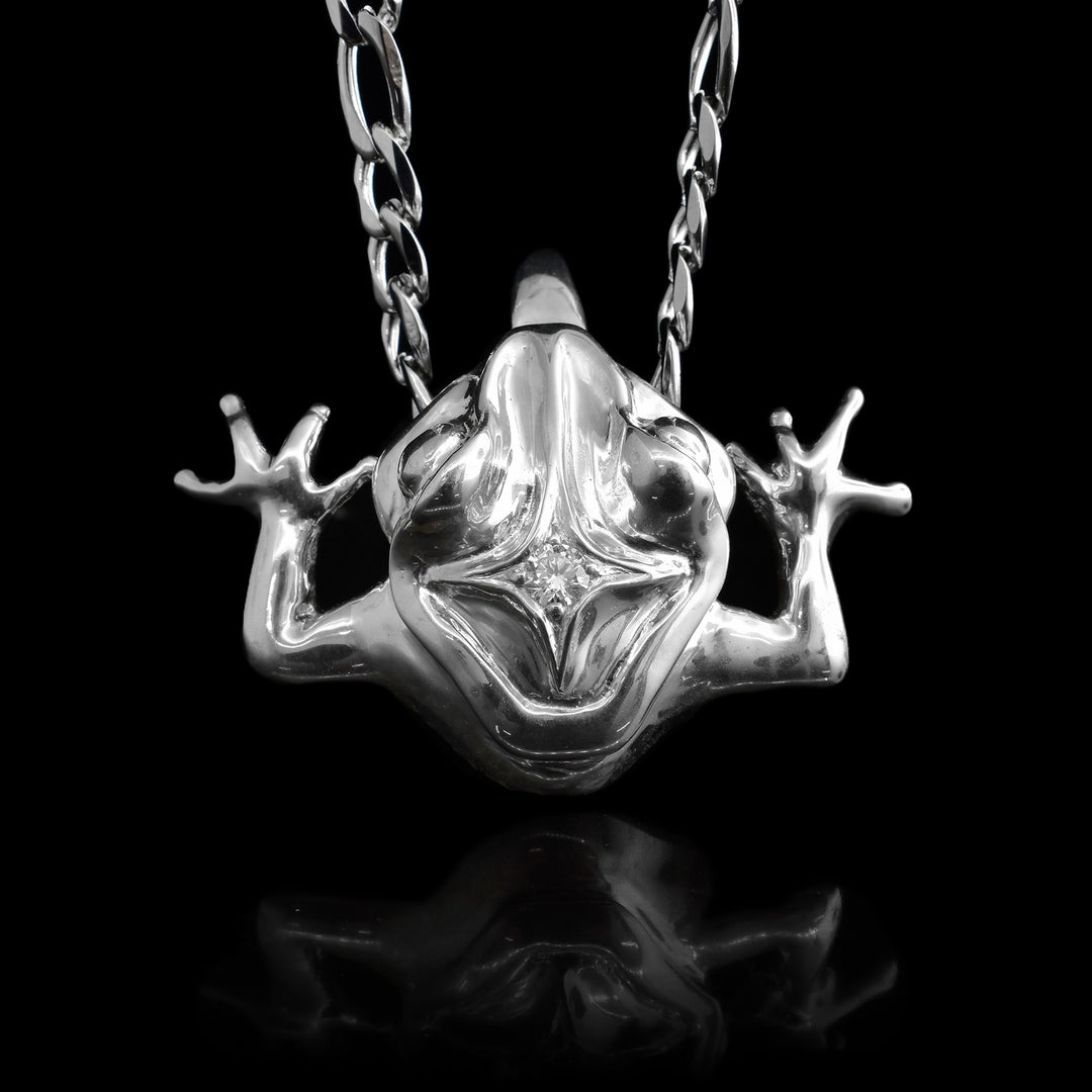 Sterling Silver Frog With Diamond, made by Gina Mae this pendant is and over head shot of the frog sticking its tounge out. There is a diamond settled into the crown of its head.