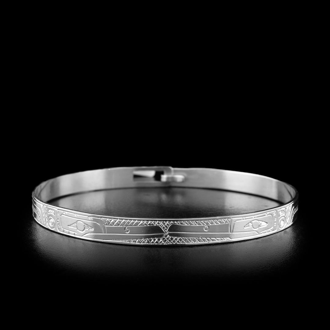 This sterling silver Hummingbird bracelet is 3/16" wide and depicts two Hummingbirds that are facing each other. The bodies of the Hummingbirds are carved around the rest of the bracelet.