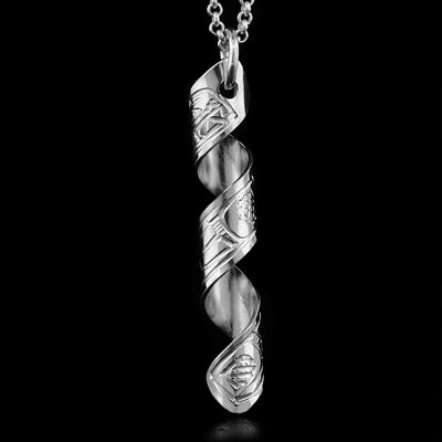 This pendant is made out of a sterling silver strip which has the face and body of the Orca carved on it and then coiled into a spiral.