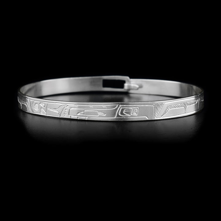 This sterling silver Thunderbird bracelet depicts the face of the Thunderbird on the front. The body of the Thunderbird is depicted around the rest of the bracelet. There is a clasp on the back.