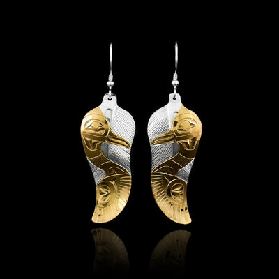 These sterling silver and gold-plated earrings are hand carved by Tlingit artist Fred Myra. He first carved the silver pieces and then applied 18K gold-plating to them.