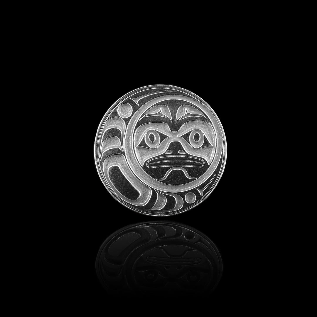 This sterling silver golf ball marker is perfectly circular and features a hand-carved Moon design at its center.