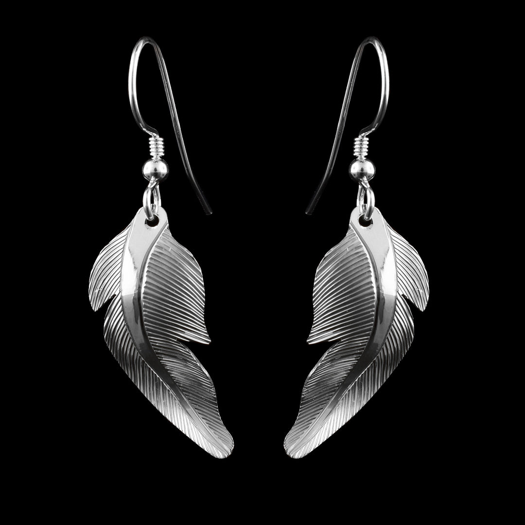 Sterling silver Heron feather earrings handcrafted by artist Fred Myra with detailed engraved lines and flowing design.