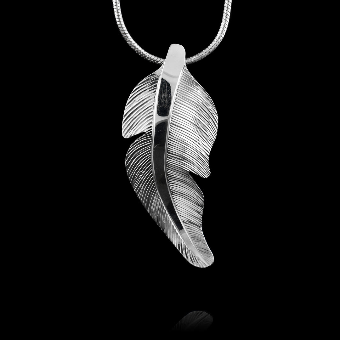 Sterling silver heron feather pendant handcrafted by artist Fred Myra with detailed engraved lines.
