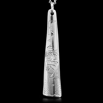 This pendant is made out of sterling silver. It has the shape of a long triangle. The face of the Hummingbirdis carved on it, facing downwards.
