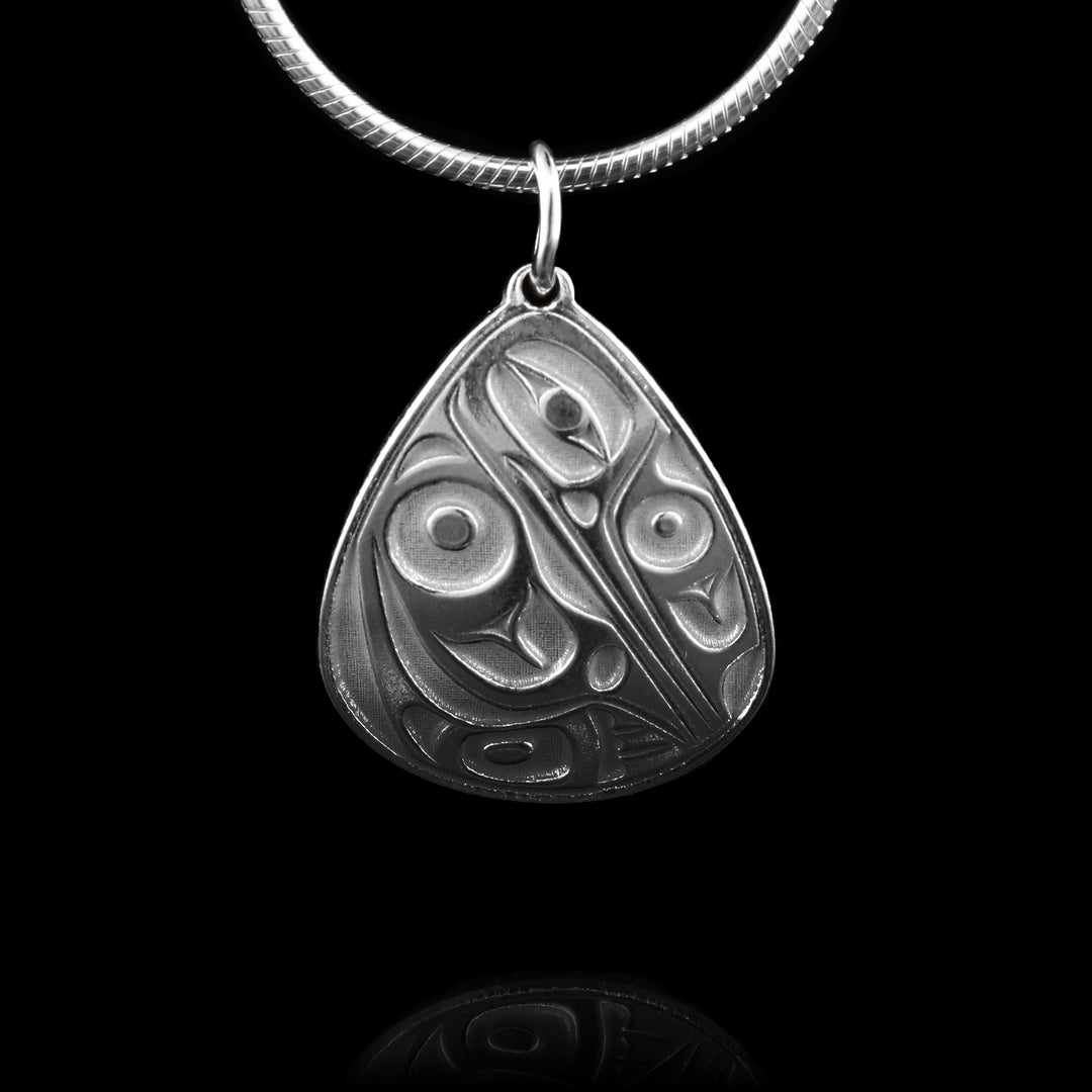 This sterling silver teardrop pendant is hand-carved with the symbol of the hummingbird.