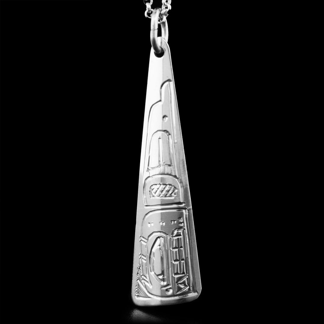 This sterling silver Orca pendant has the shape of a long triangle. The face of the Orca is depicted on it, facing downwards.
