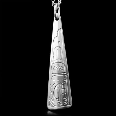 This sterling silver pendant has the shape of a long triangle. The face of the Orca is depicted on it, facing downwards.