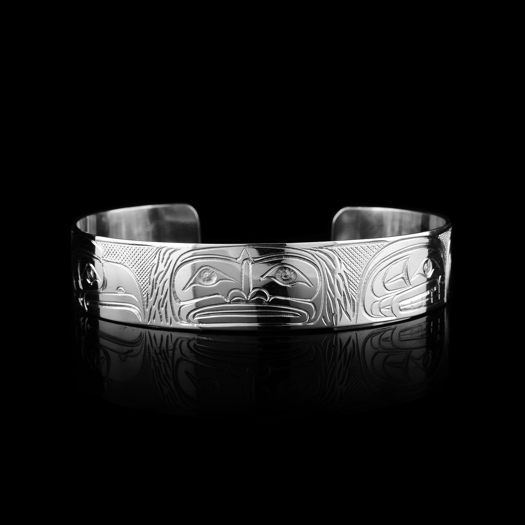 Shop this Travis Henry sterling silver cuff. Hand-carved by the Coast Salish artist, this band features a masterfully engraved Sasquatch, Eagle, Raven, and Orca. around the silver cuff.