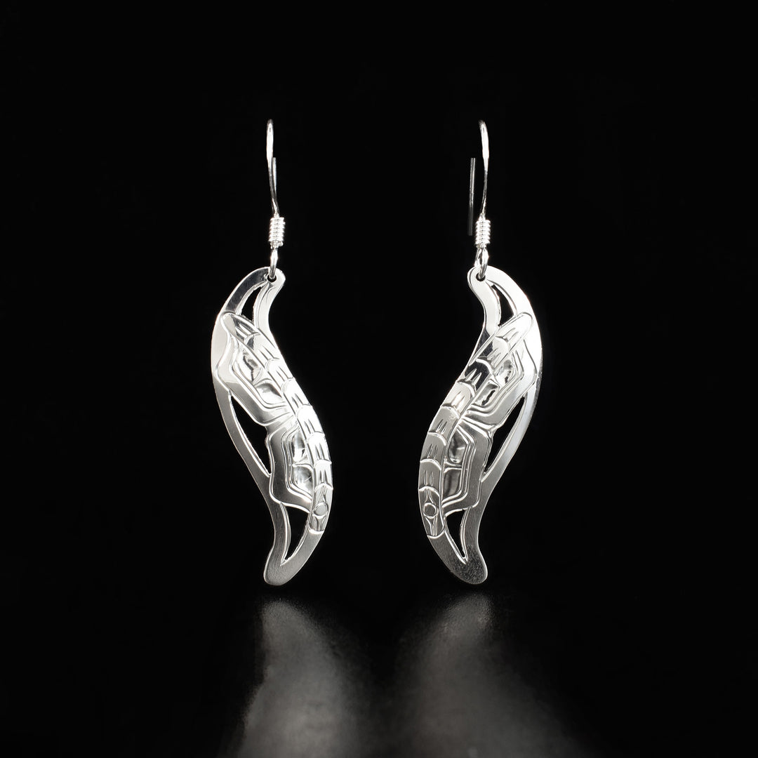 Hand-carved and cut by Kwakwaka’wakw artist Harold Alfred. Leaf-shaped frames hang from hooks. Both frames have a side-view of a butterfly with wing out facing downwards.