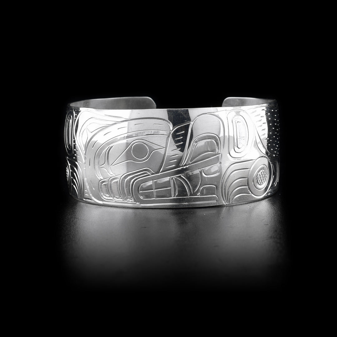 This Bear bracelet has a wide, sterling silver band with a gap in the band. There is a a depiction of the Bear carved into the surface of the band. The head of the legend is depicted in the center of the piece.