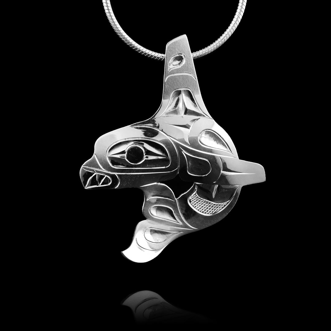 Handcrafted sterling silver orca pendant with polished form line details inspired by Northwest Coast art.