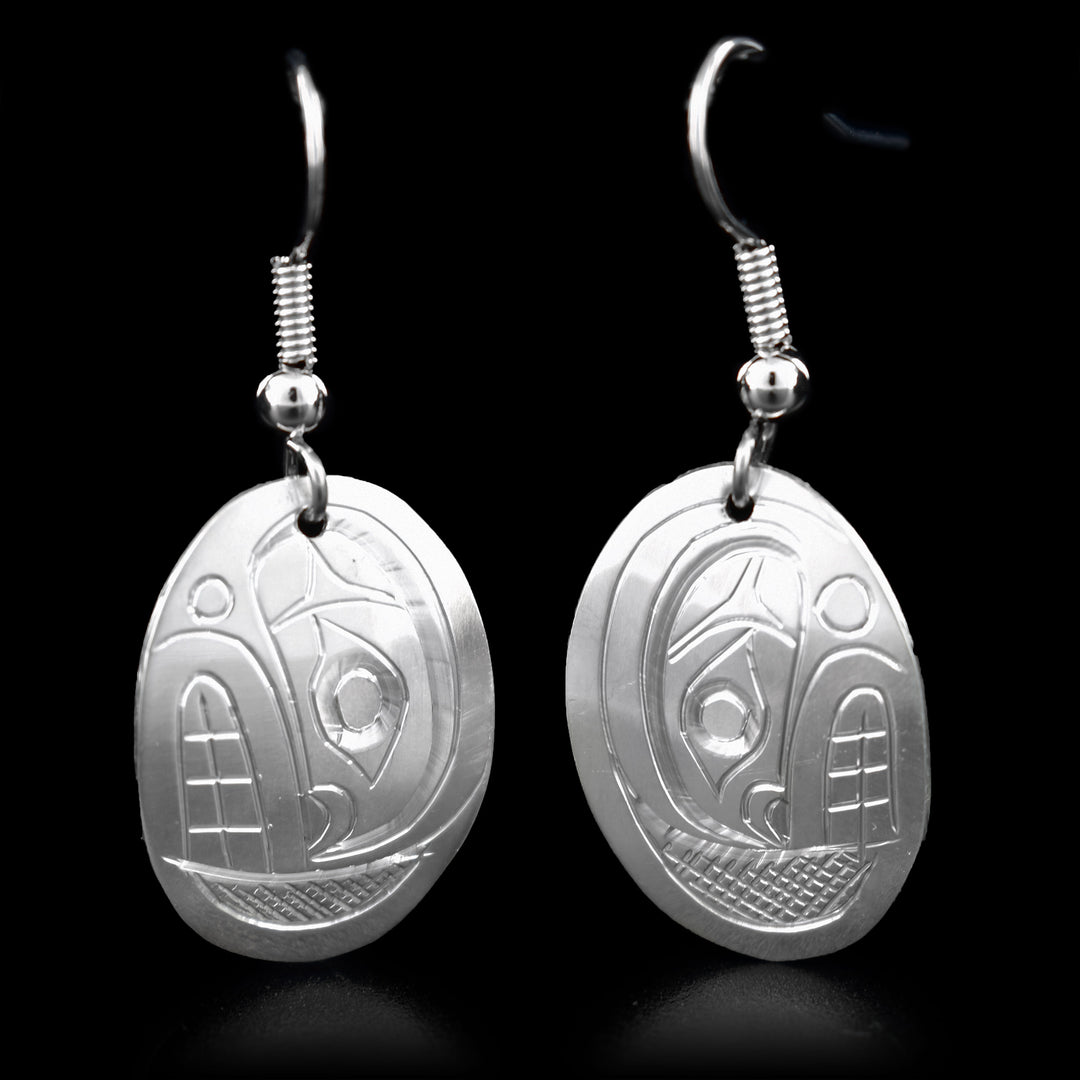 These dangling Orca earrings are made from sterling silver and the hangs are oval shaped. There are depictions of the Orca carved into the surface of the hangs.