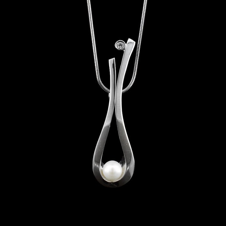 Delicate balance with sterling silver, pearl and cubic zirconia, sterling silver loops down so the pearl sits on the loop. at the end is a round cubic zirconia. 