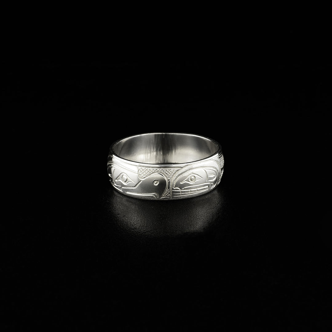 This silver ring has the profile of a thunderbird on the left facing towards the profile of an orca on the right.