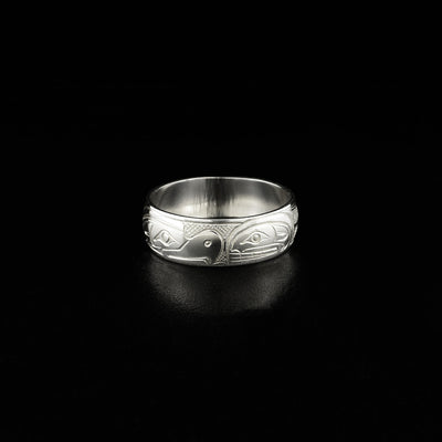 This silver ring has the profile of a thunderbird on the left facing towards the profile of an orca on the right.