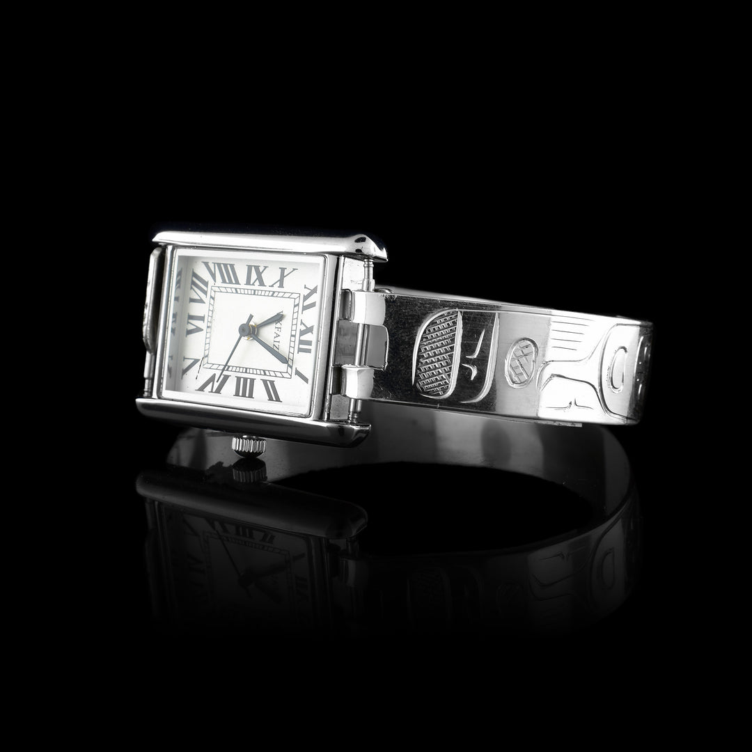 This sterling silver watch has a rectangular clock and is attached to a sterling silver band carved with the legend of the Raven around it.