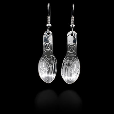 These sterling silver earrings are spoon-shaped. They have the Raven's face handcarved on them. They also have silver hooks.