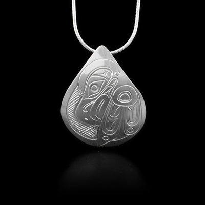 Domed sterling silver teardrop pendant featuring side-view of eagle. Cross-hatching background. Hidden bail on back. By Kwakwaka’wakw artist Don Lancaster.