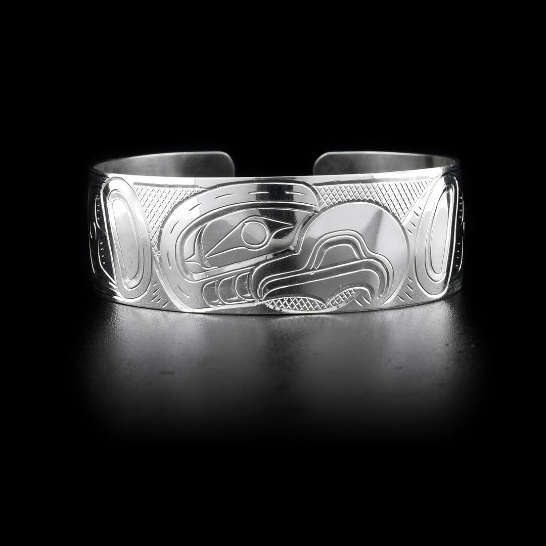 The Eagle bracelet has a wide, sterling silver band with a gap in the back. There is a depiction of the Eagle carved into the surface of the band. The head of the legend is placed in the center of the piece.
