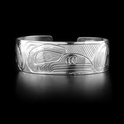Bracelet features raven head facing left on front with cross-hatching background. Hand-carved by Kwakwaka’wakw artist William Cook.