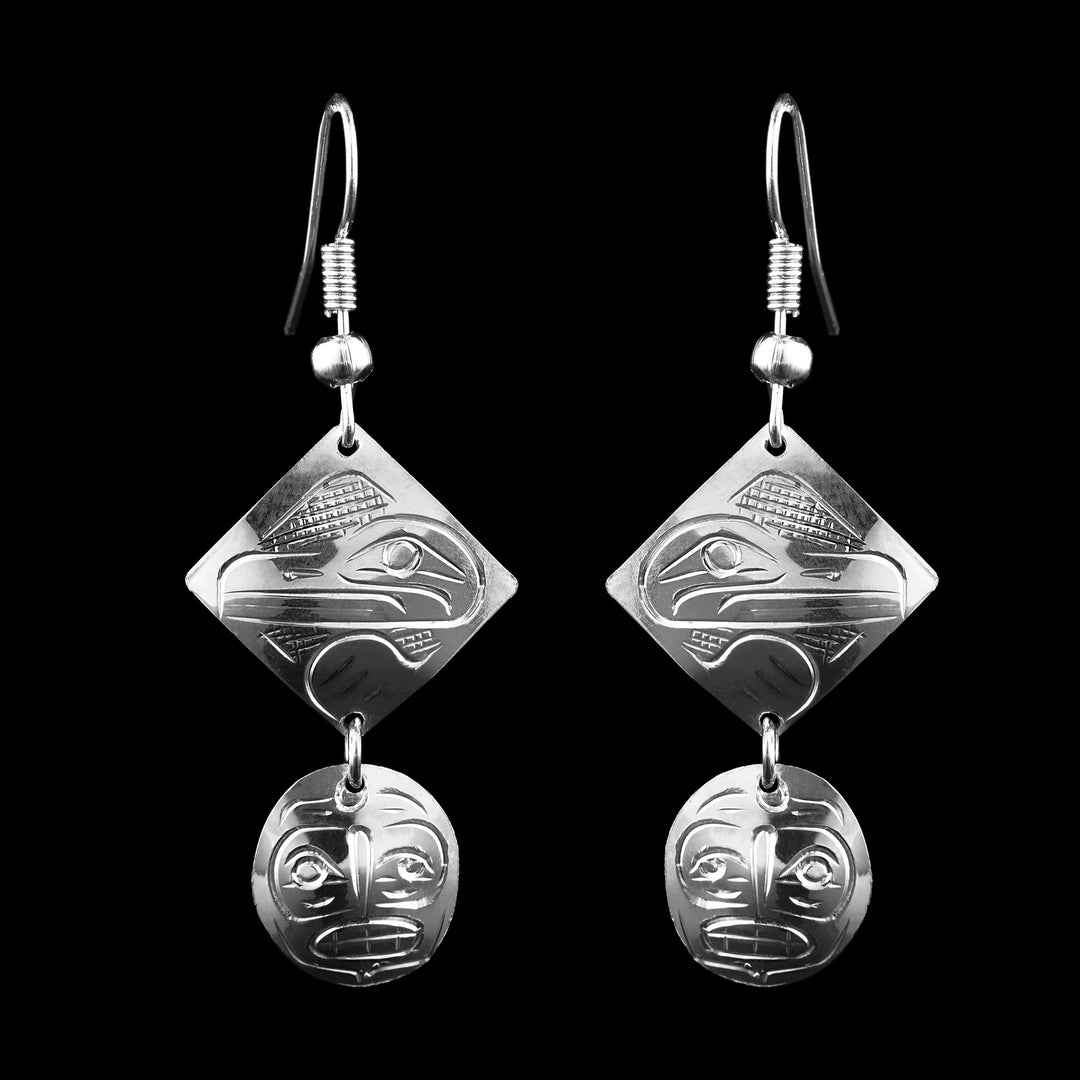 Sterling Silver Tiered Dangle Raven and Moon Earrings. The first level of the earring has a Raven carved into the surface. Hanging below the Raven is the legend of the Moon on a circular charm. 