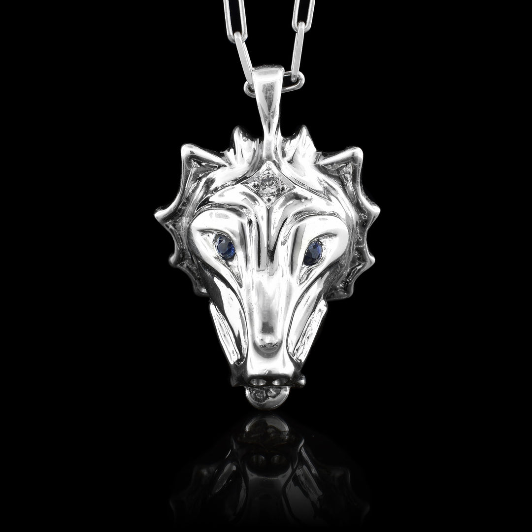 Sterling Silver Wolf Head Sapphire Eyes a top a Diamond, 3D sterling silver wolf head pendant handcrafted by Haida Gwaii artist Gina Mae Schubert, featuring inset blue sapphire eyes and a diamond accent on the forehead.