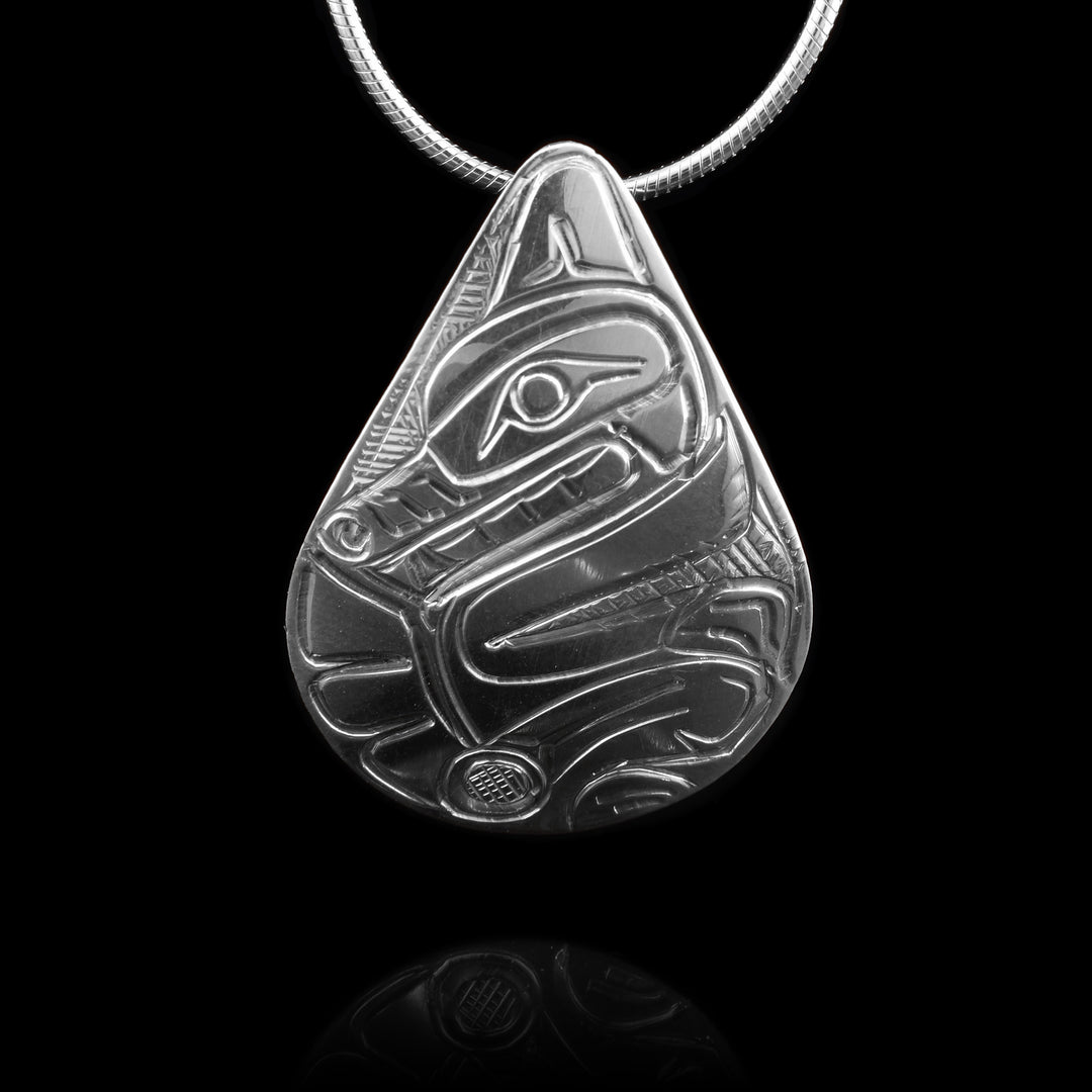 This Sterling Silver Wolf Teardrop Pendant is carved in a traditional indigenous technique. The wolfs head carved at the top its nose tucking into its tail.