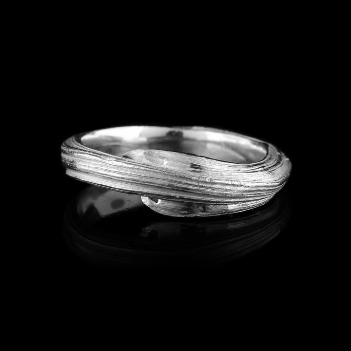 the Ribbon Ring by Lisa-Marie Masse. This hand-crafted sterling silver band features unique layered textures and an organic, wrapped silhouette. Shop artisan elegance.