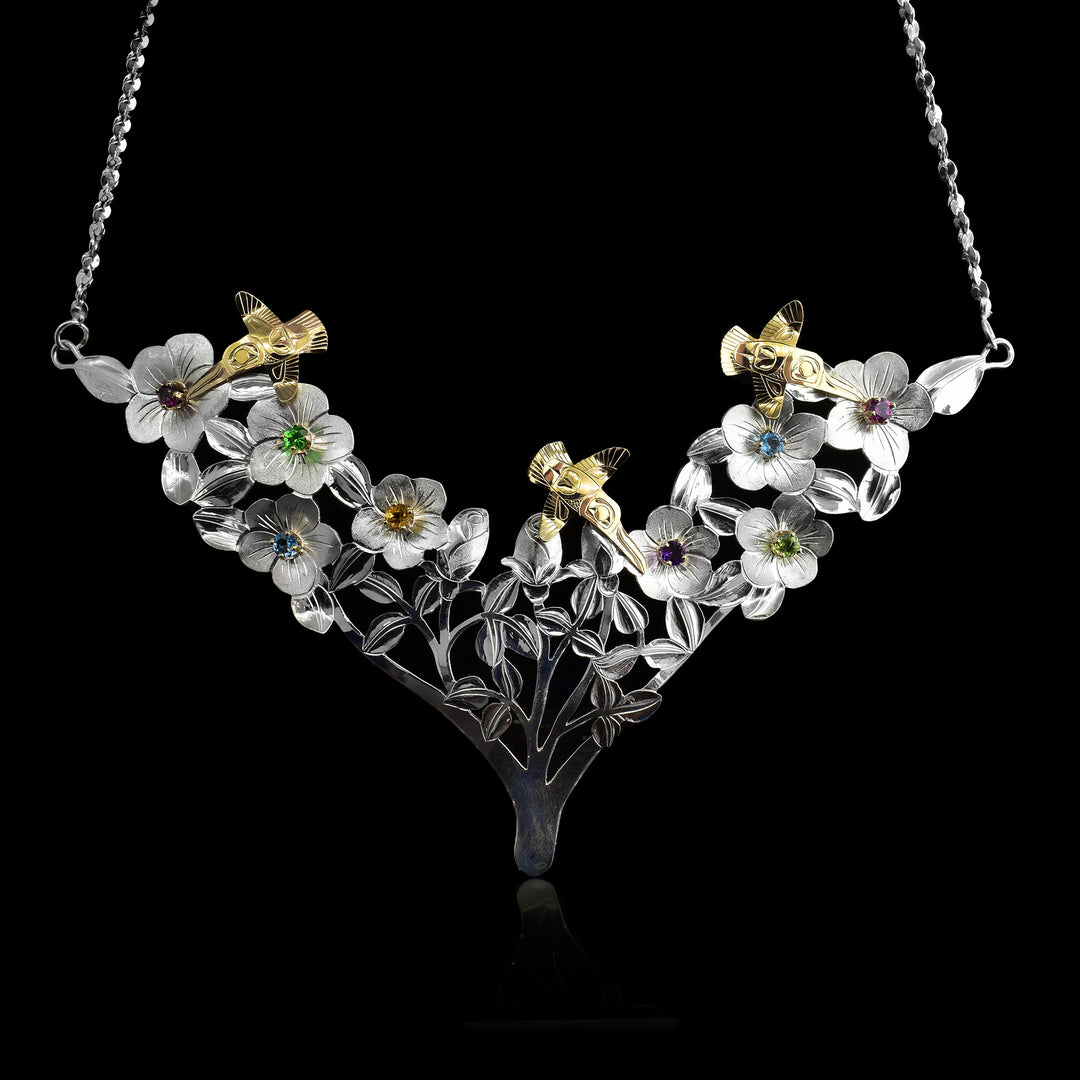 Sterling Silver and 14k Gold Hummingbirds Garden of Gems Necklace. A garden of sterling silver flowers and in the middle of the flowers are set gemstones of different colours citrine, blue topaz, tsavorite, rhodolite garnet, peridot and amethyst. Above the flowers fly 3 hummingbirds that are plated in 14k gold.
