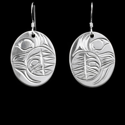 Sterling silver dangle earrings depicting a crescent moon with a sun inside. Hand-carved by Kwakwaka’wakw artist Cristiano Bruno.