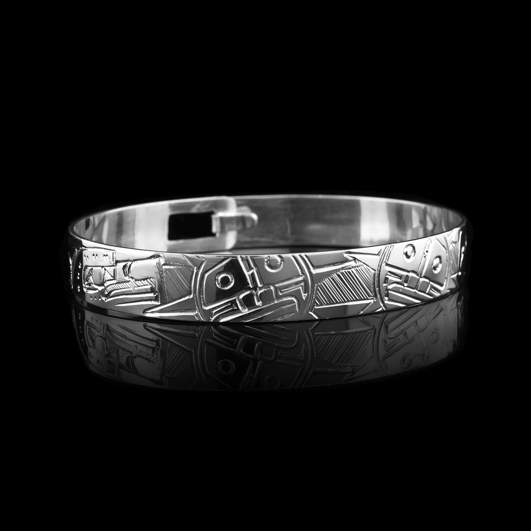 This sterling silver bangle bracelet features hand-carved designs of the Eagle and Sun. The Eagle represents strength and vision, while the Sun symbolizes life and energy. Finished with a smooth clasp, this bracelet is both meaningful and comfortable to wear.