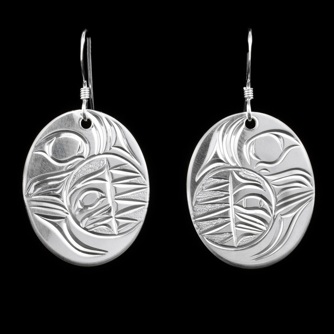 Sterling silver sun and moon earrings depicting a crescent moon with a sun inside.