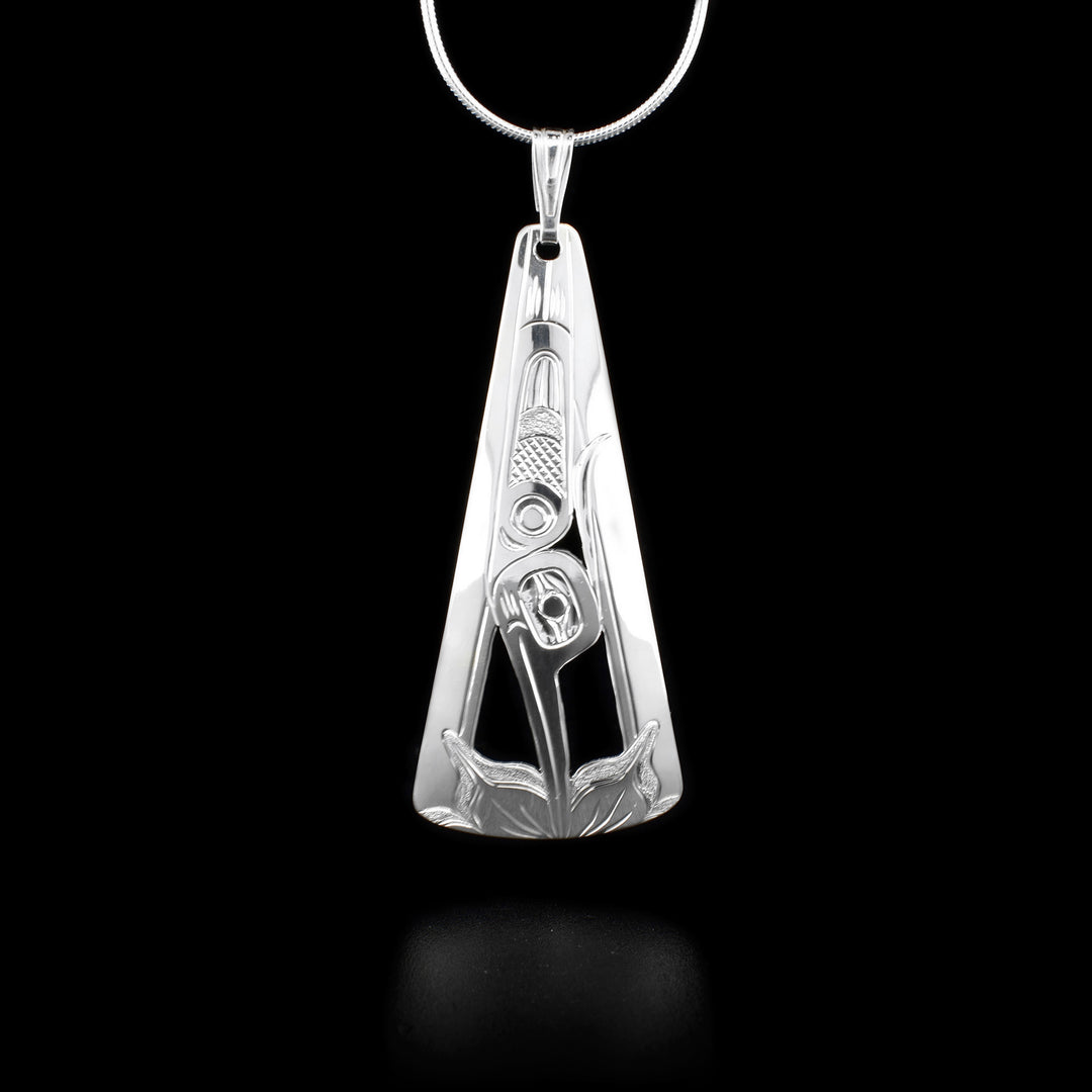 Sterling silver rounded, triangular pendant featuring hummingbird pointing downwards with beak in flower on bottom. Hand-carved and cut by Kwakwaka’wakw artist Harold Alfred.