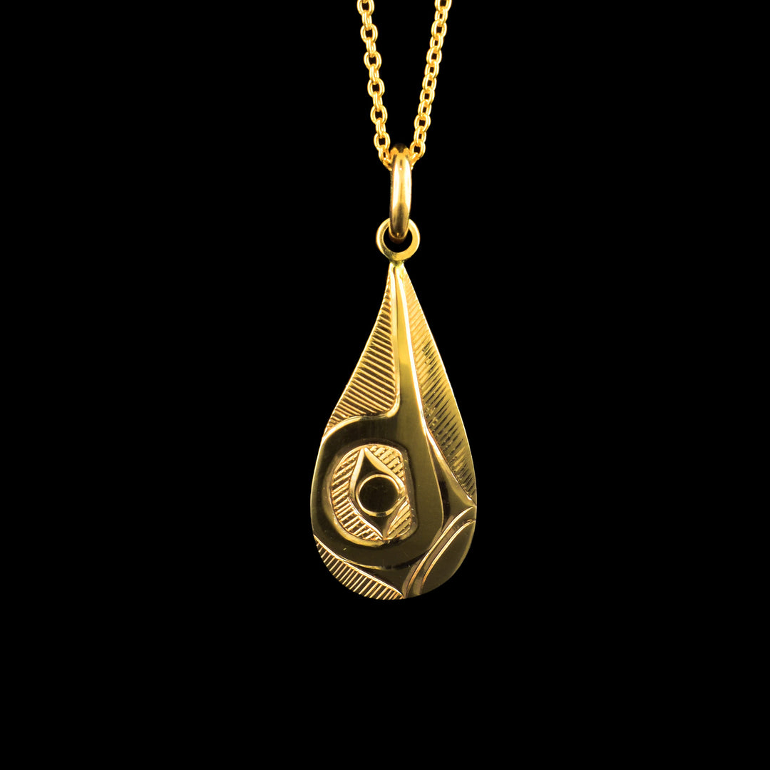 This 14K gold Hummingbird pendant has a teardrop shape and is made of solid gold. There is a side profile depiction of the Hummingbird with its beak pointing upwards carved into the surface of the piece.