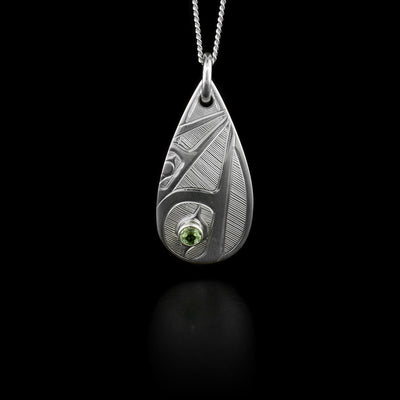 Sterling silver hummingbirds pendant hand-carved by Haisla artist Hollie Bartlett. Hummingbird head in forefront has a peridot set in eye. Finely carved lines in background.