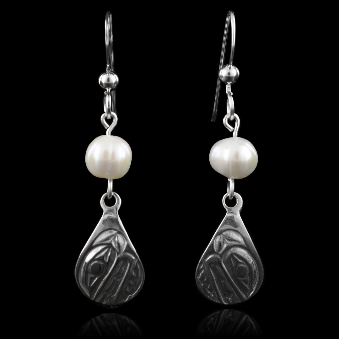 These sterling silver teardrop earrings feature have orca engravings, topped with a white freshwater pearl and suspended from classic French hooks.